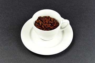 Coffee cup on a dish with coffe beans