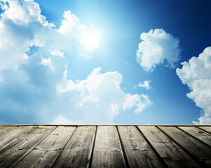 Naklejka na ściany i meble Cloudy blue sky and wood floor