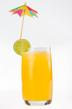 Glass of fruit juice lime slice and umbrella