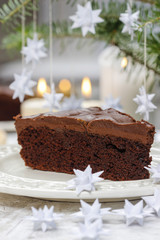 Piece of chocolate cake in white christmas table setting