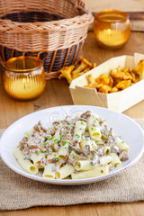 Macaroni with mushrooms on wooden rustic table. Autumn setting