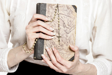 Obraz na płótnie Canvas Holy Bible and white rosary in beautiful hands