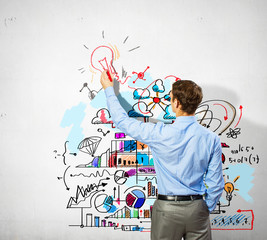 Businessman drawing sketches on wall