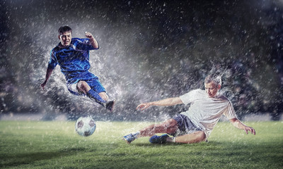 Fototapeta na wymiar two football players striking the ball