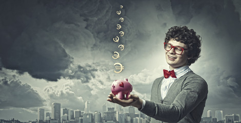 Young businessman holding moneybox