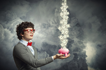 Young businessman holding moneybox