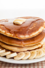 Stack of pancakes with honey and banana.