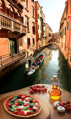 Venice with Italian pizza against canal in Italy