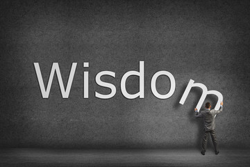 Businessman collects on the wall the word wisdom