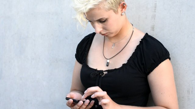 Woman concentrated using her smartphone and looking up