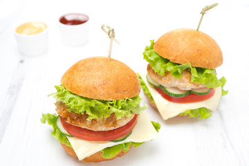 chicken burger with vegetables, cheese and sauces on board