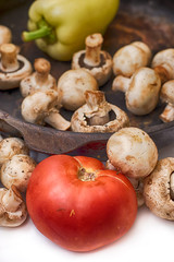 Mushrooms and fresh vegetables on the rusty pan
