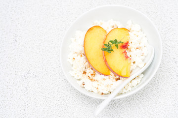 cottage cheese with honey, nuts, fresh peaches, thyme, top view
