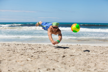 junger sportlicher mann im sprung beim beach volleyball
