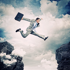 Businessman jumping over gap