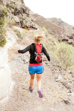 Woman trail running in mountains