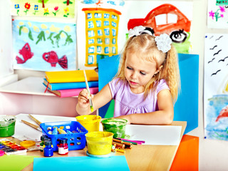 Child painting at easel.