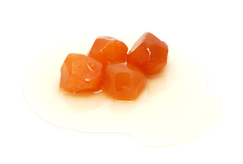 Four pieces of preserved ginger in sweet syrup