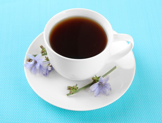 Cup of tea with chicory, on blue background