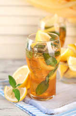 Iced tea with lemon and mint on wooden table