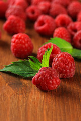 Ripe sweet raspberries on wooden background