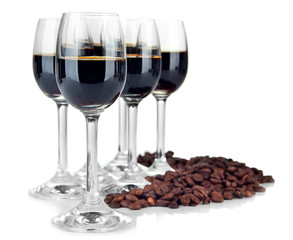 Glasses of liquor and coffee grains, isolated on white