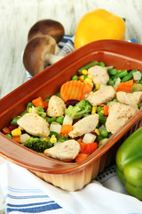 Casserole with vegetables and meat, on wooden background