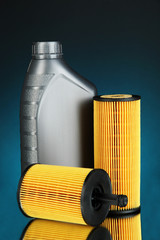 Car oil filters and motor oil can on dark color background