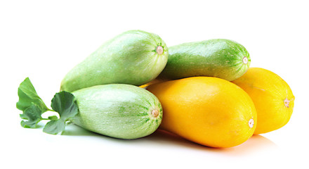 Raw yellow and green zucchini with leaves, isolated on white