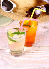 Green, orange cocktails with straw and holiday background