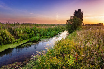 Summer sunset around field and river