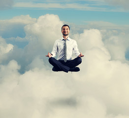 man in formal wear meditating in the sky