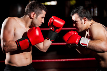 Fototapeta na wymiar Strong boxer and his opponent during a box fight in a ring