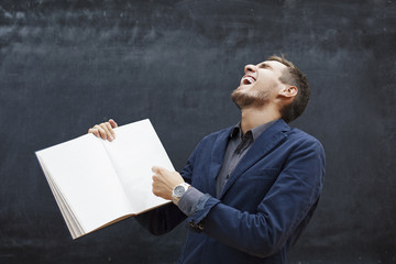 cheerful teacher shows in the book and laughs