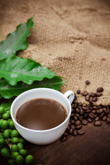 Cup coffee and beans on wood background