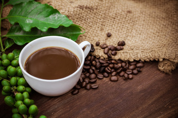Cup coffee and beans on wood background