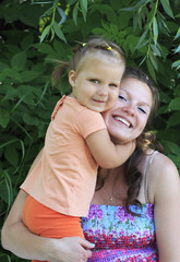 Little girl tenderly embraces his mother.