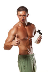 Muscular man holding a plastic bottle and showing thumbs up