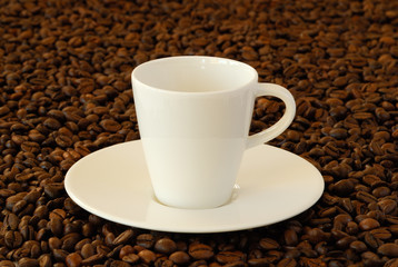 Espressotasse inmitten von Espressobohnen
