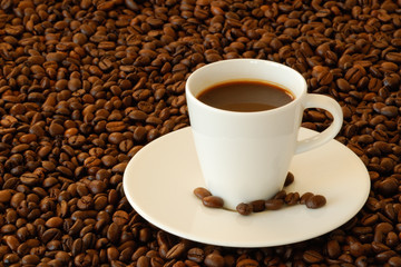 Espressotasse inmitten von Espressobohnen