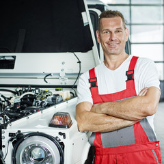 Car mechanic in front of a car in a garage