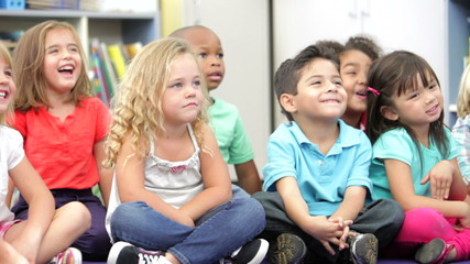 Group Of Elementary Age Schoolchildren Sitting On Floor - Powered by Adobe