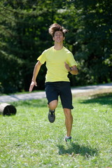 Young handsome athlete warming up in the park