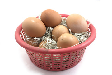 Brown eggs in the basket on white.