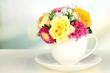 Beautiful bouquet of bright flowers in color mug,