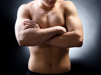 Handsome young muscular sportsman, on dark background