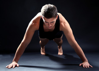 Fototapeta na wymiar Handsome young muscular sportsman, on dark background