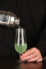 Bartender making cocktail on bright background, close-up
