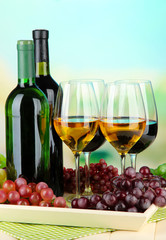 Obraz premium Wine bottles and glasses of wine on tray, on bright background
