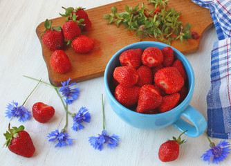 Summer still-life with cornflowers and blue mug with fresh straw